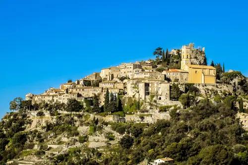 Scenic view of Eze with cacti, French flag, and Mediterranean Sea.